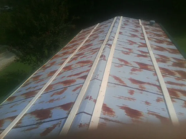 Rusted metal roof panels with new wood purlins before replacement — Storm Damage Roof Repair in Renton by Roofing Brothers