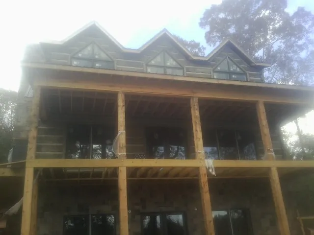 Dormers and porch framing on a large log home under construction — Roof Coating work by our crew in Renton
