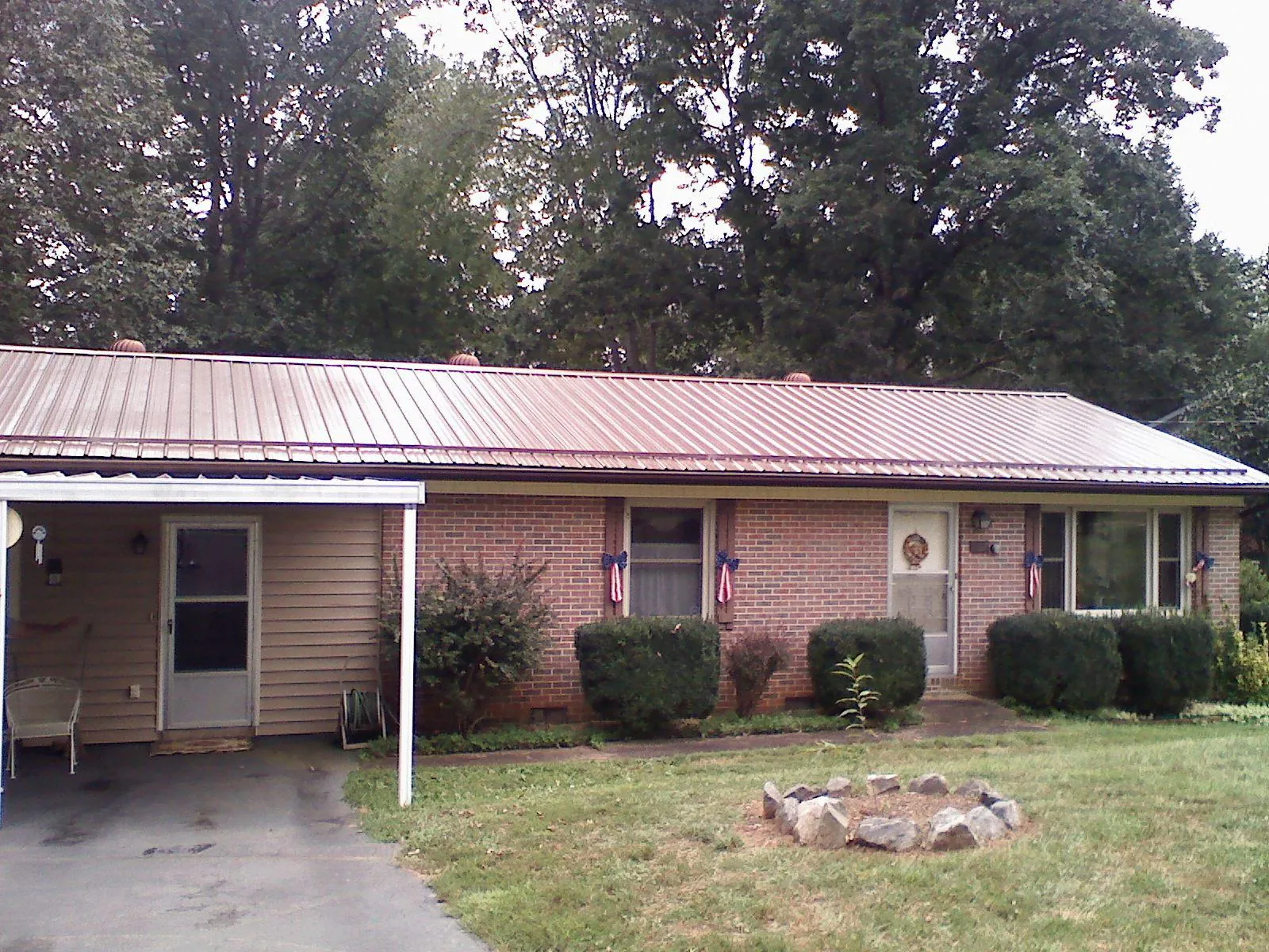 Bronze metal roof and carport on a brick ranch home — Roof Repair work by our crew in Renton
